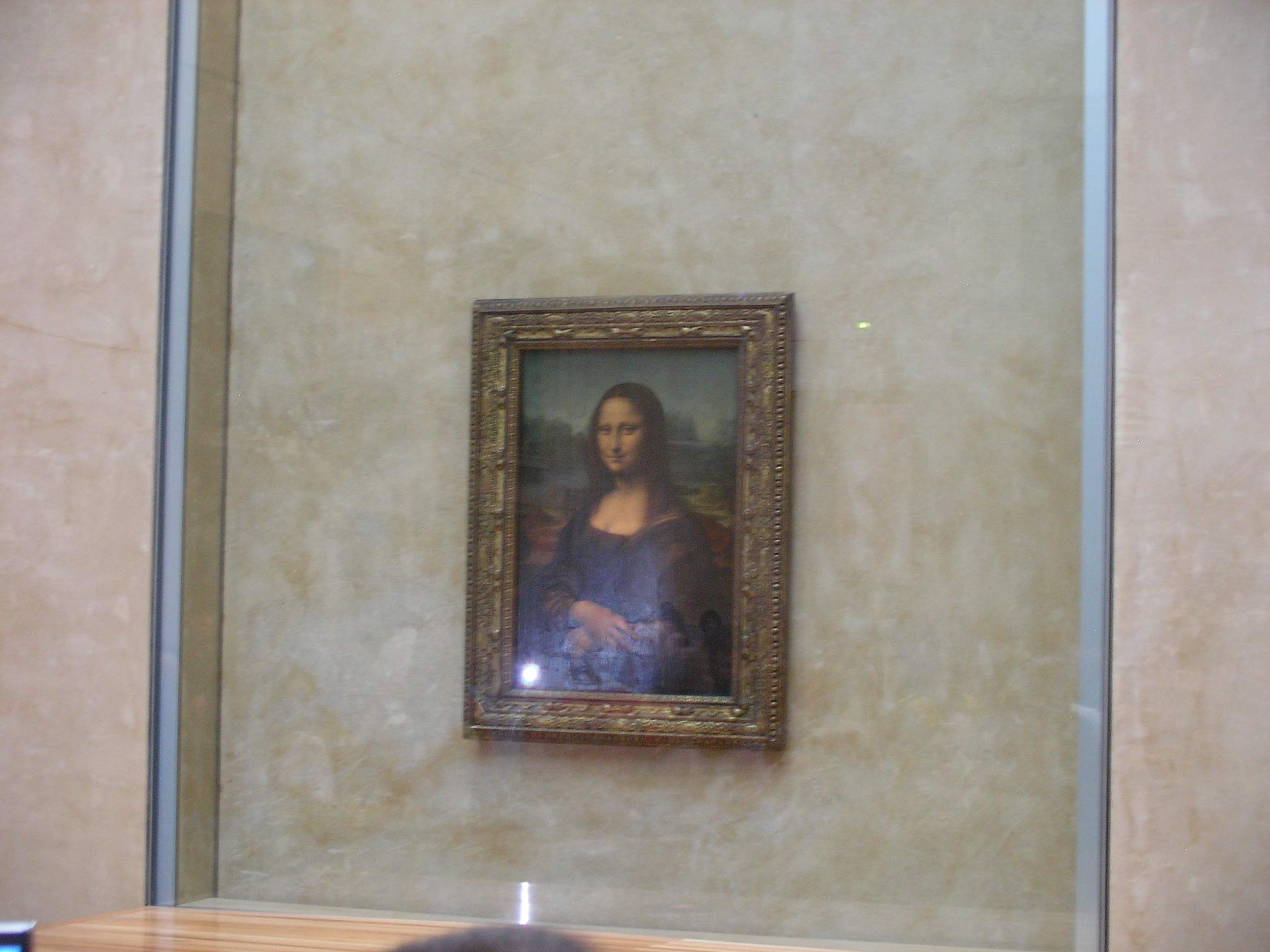 The Mona Lisa painting by Leonardo da Vinci, displayed at the Louvre Museum.