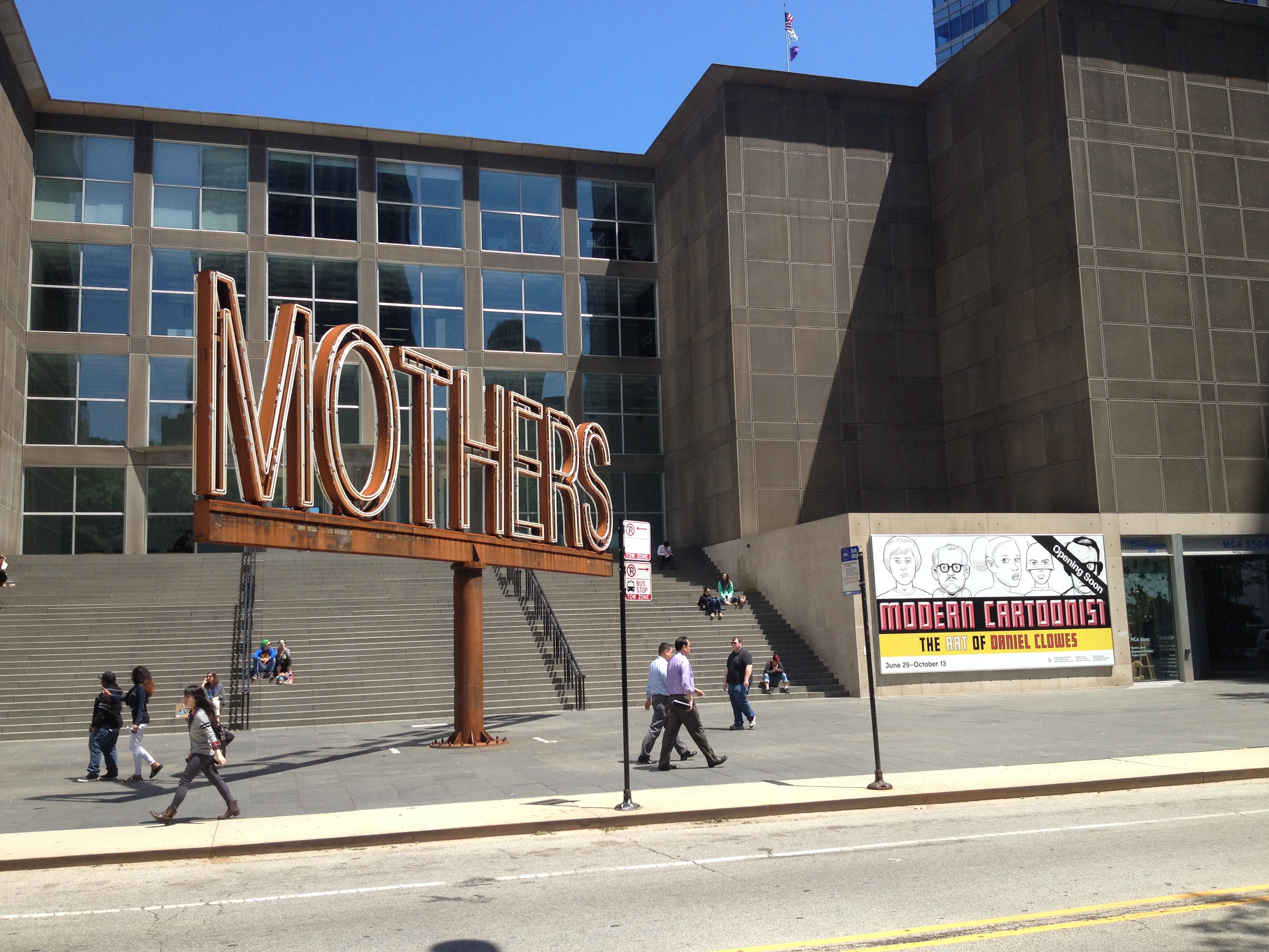 The large, rusty 'MOTHERS' sign in front of the Museum of Contemporary Art Chicago on a sunny day.
