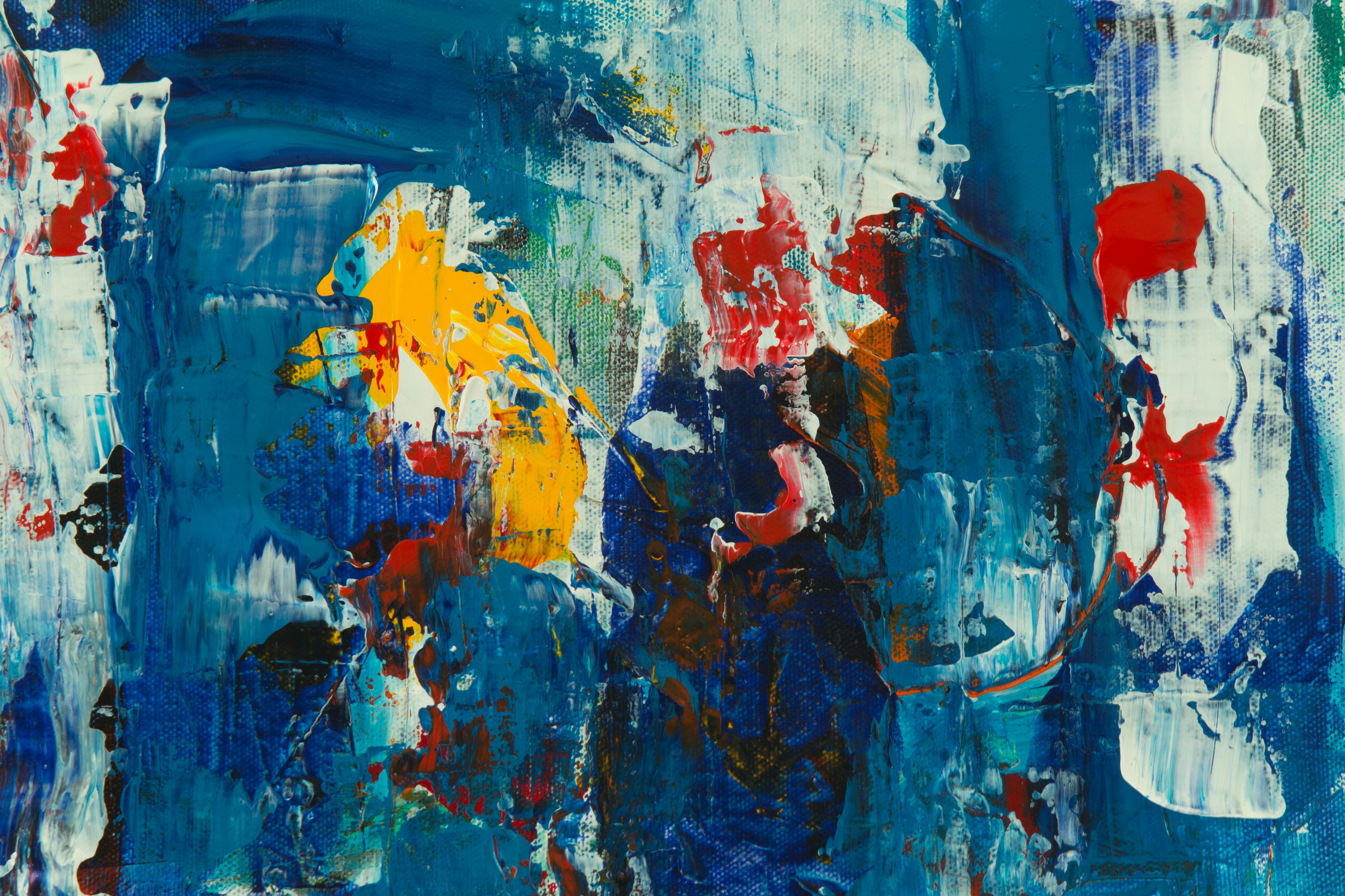 Close-up photo of an abstract painting with thick impasto strokes in blue, yellow, and red, showcasing texture and vibrant colors.