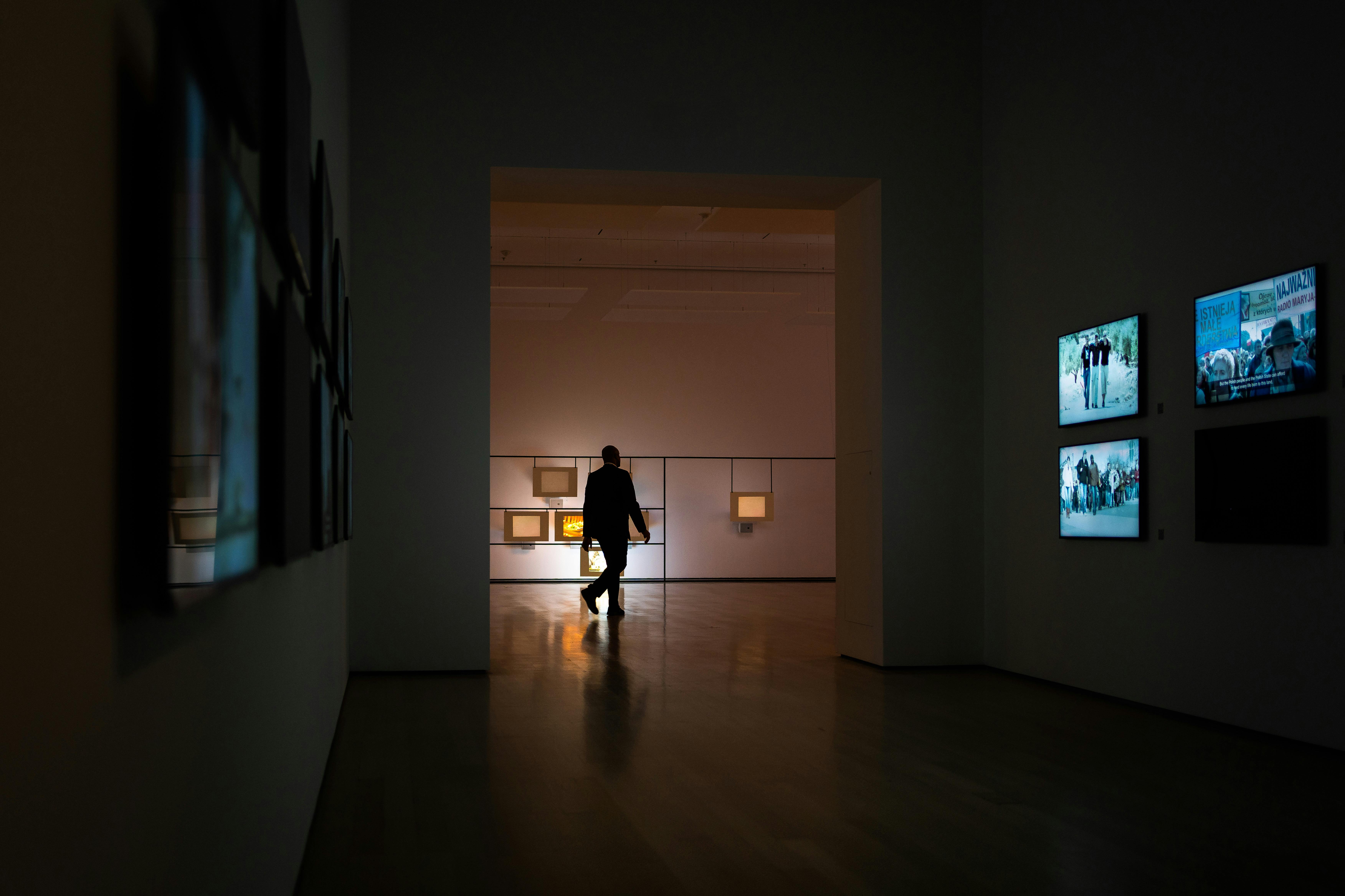 A man examines art in a modern gallery. Art collection setting, gallery walk experience, art appreciation atmosphere
