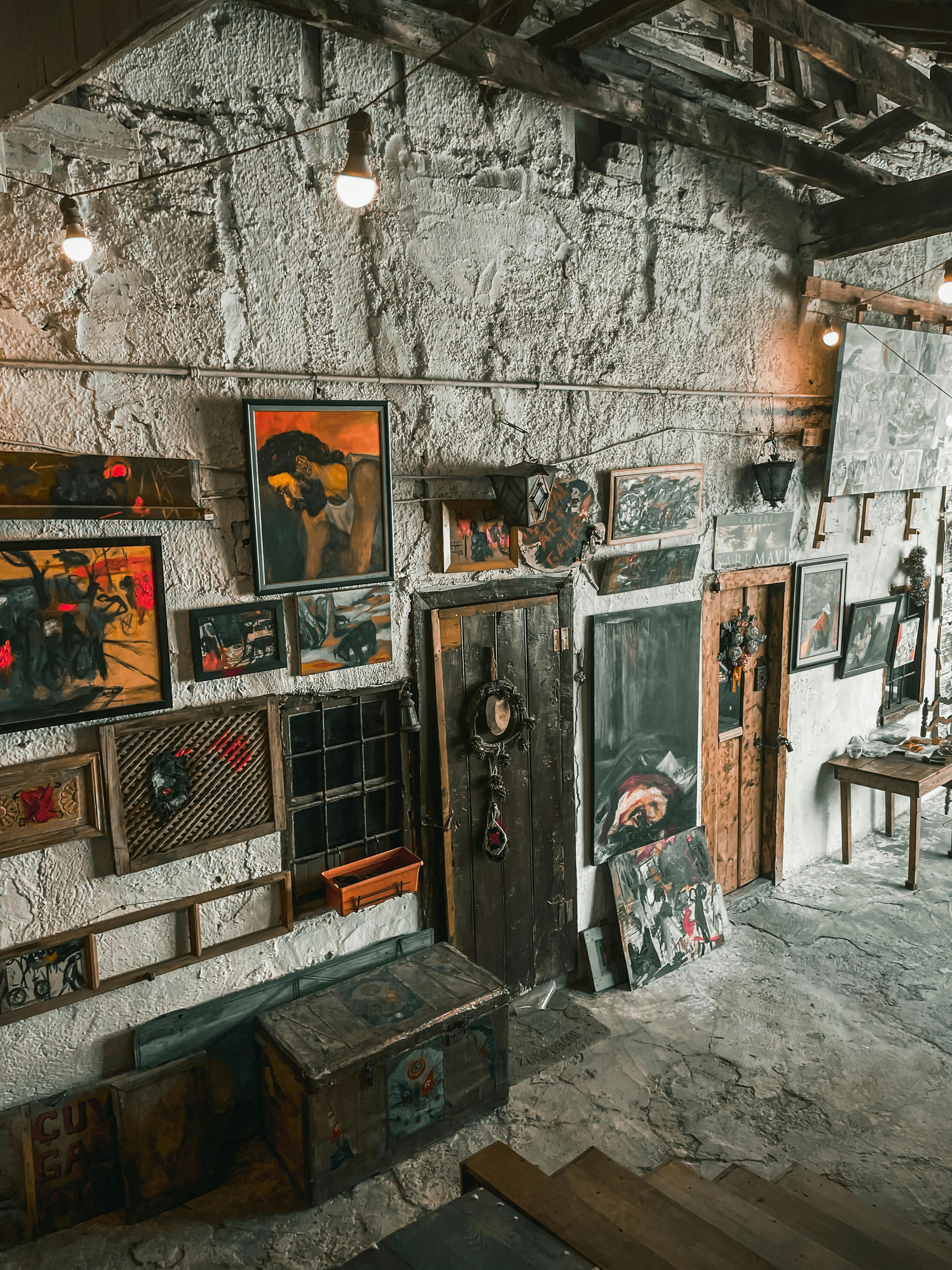 Art Gallery Walls decorated with Paintings free stock photo, textured wall backdrop with framed artwork and rustic door accents highlighting gallery ambiance in interior design context.