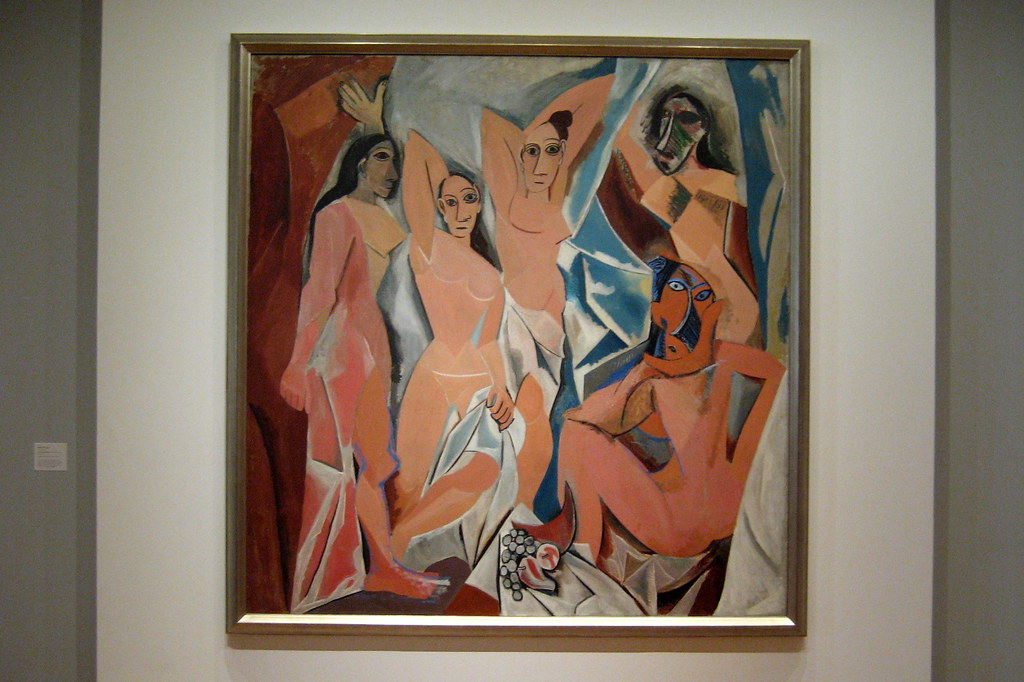 NYC's Museum of Modern Art showcases Picasso's Les Demoiselles d'Avignon, a seminal Cubist painting featuring fragmented figures and bold primitivism influence. A museum-quality photograph captures the iconic 20th-century masterpiece in its gallery setting.