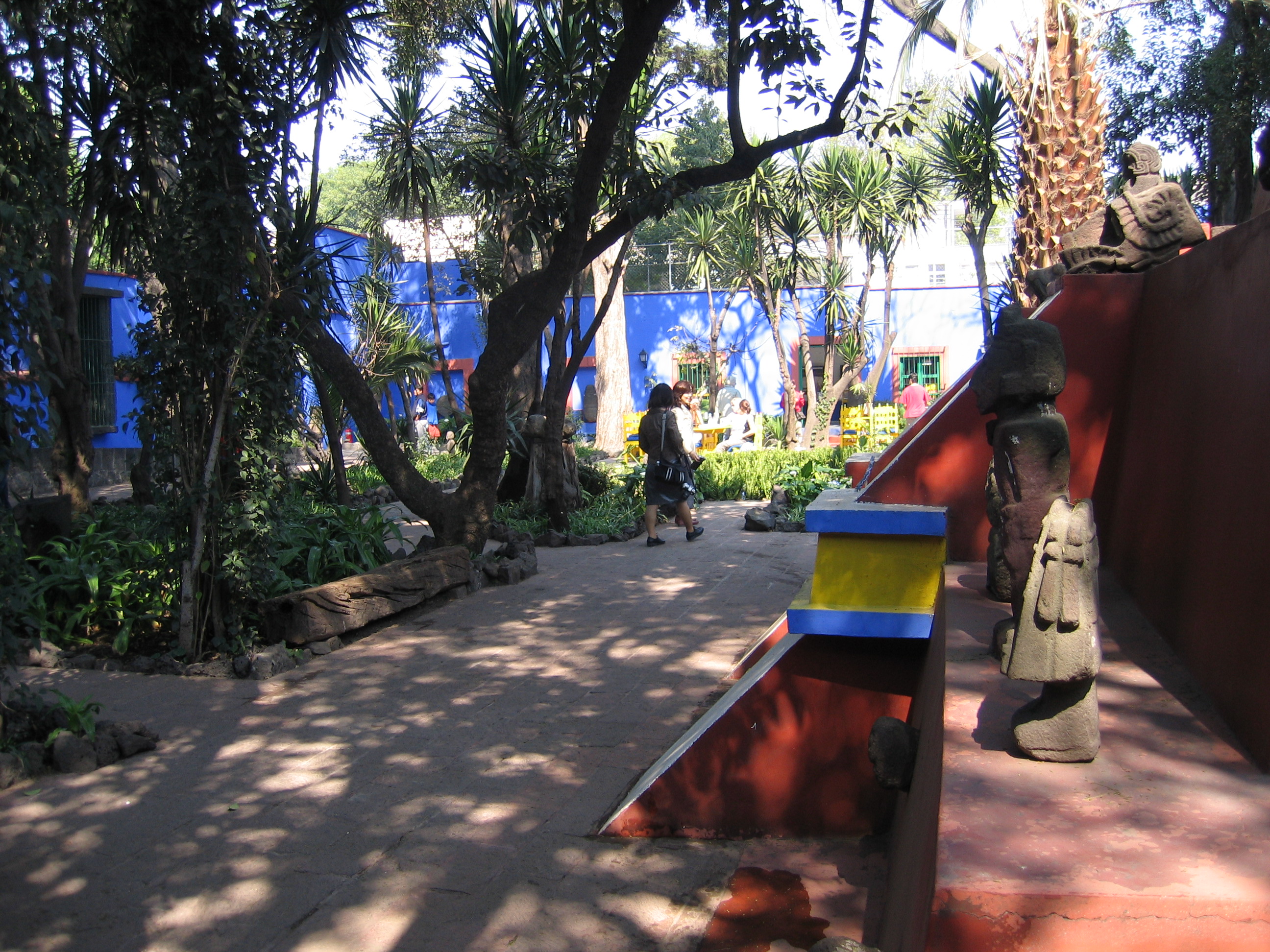 Frida Kahlo Museum garden path with blue building and stone sculptures