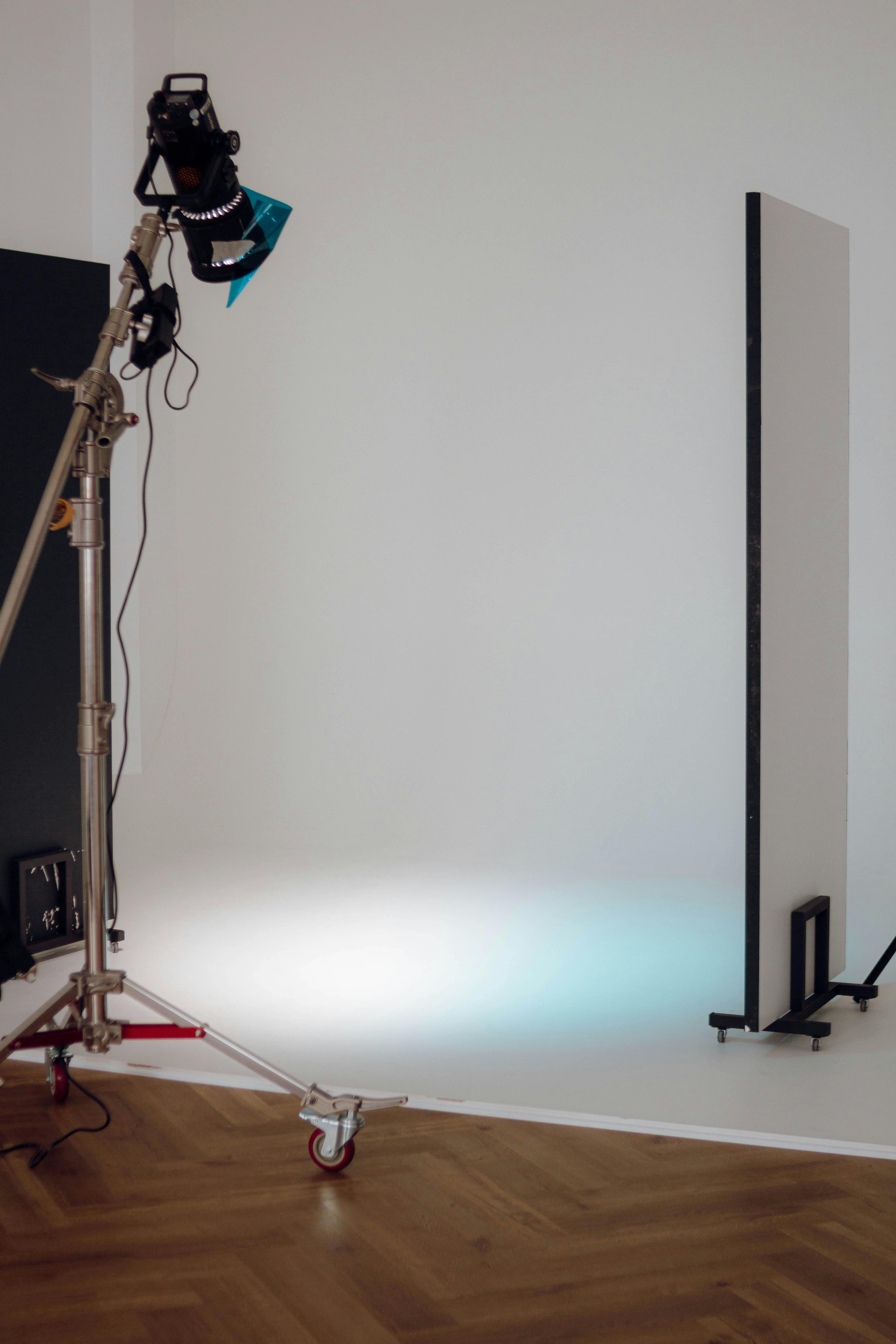 Professional photographic studio setup with lighting equipment and a white backdrop, showcasing how to properly light an art studio.