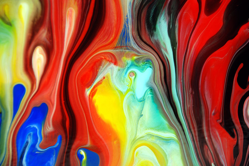 Abstracte vloeibare schildering met dynamische penseelstreken en levendige kleuren die de creatieve geest van kunstenaars vertegenwoordigen.