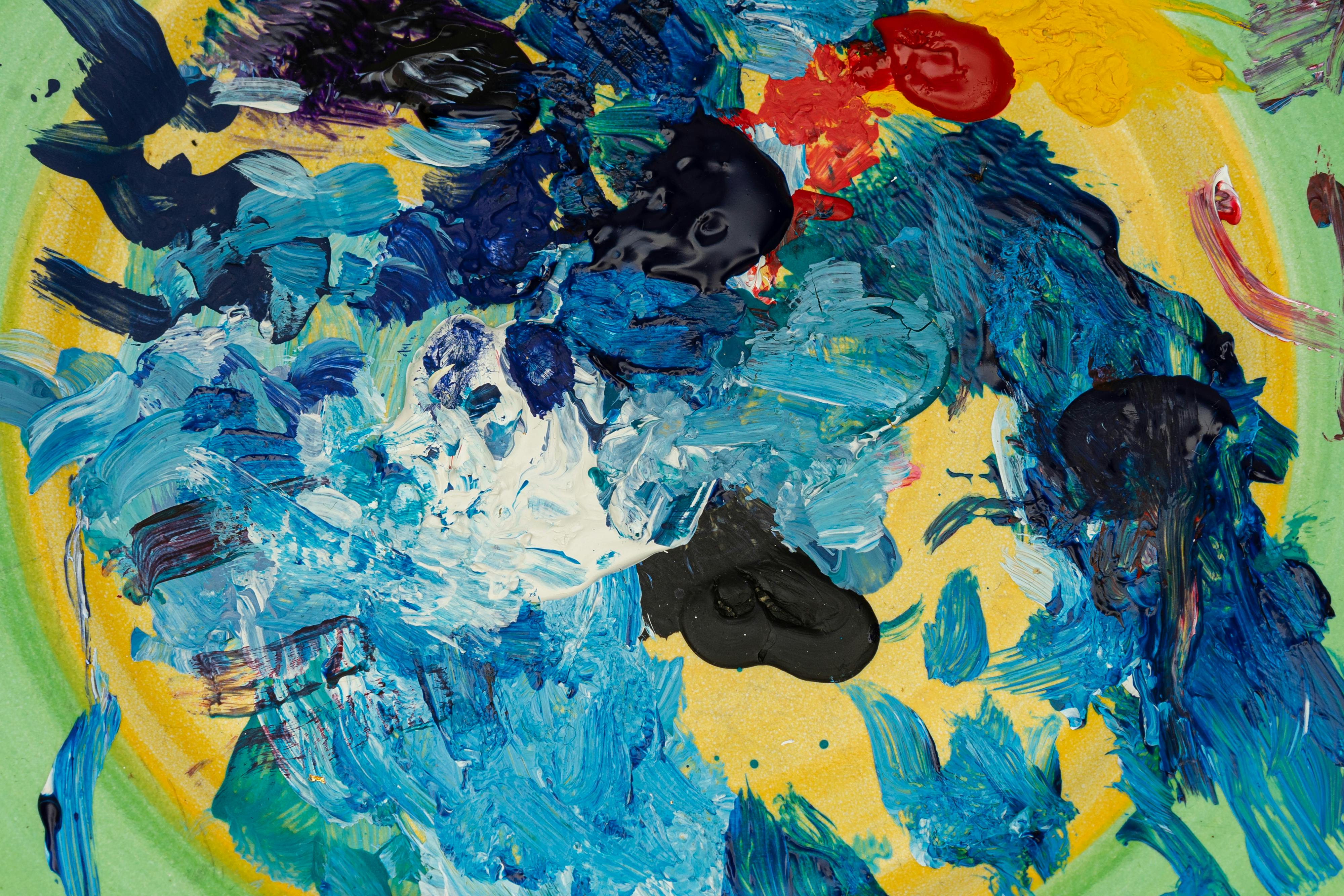 A close-up view of a paintbrush surrounded by shimmering metallic paint colors, ideal for beginner art tutorials and painting demonstrations