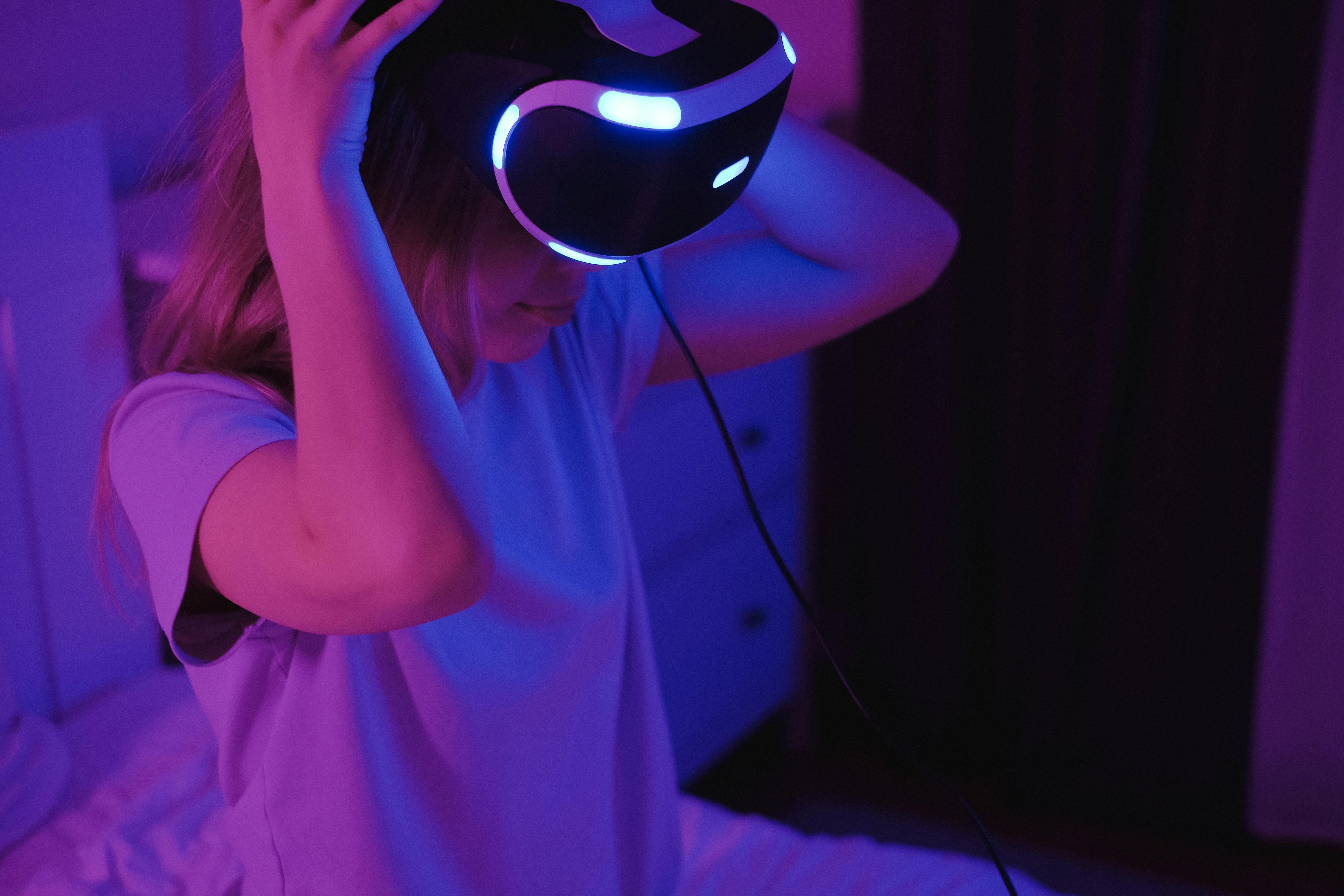 Woman interacting with virtual reality technology in a dimly lit environment, showcasing modern digital engagement with immersive digital art.