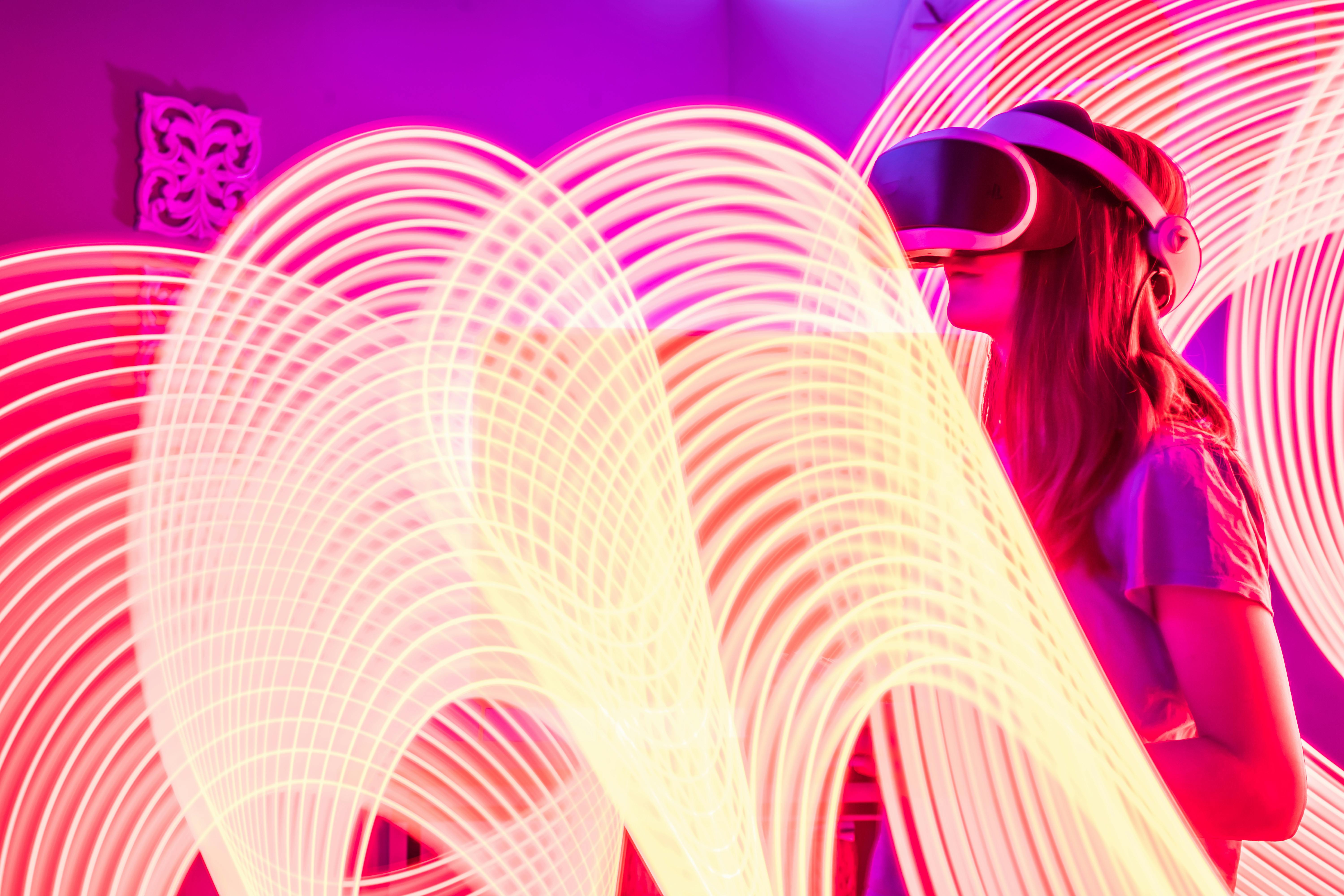 A woman wearing VR goggles amidst dynamic digital light trails, symbolizing emerging art-technology fusion in immersive exploration contexts. AR, virtual reality, digital innovation art.