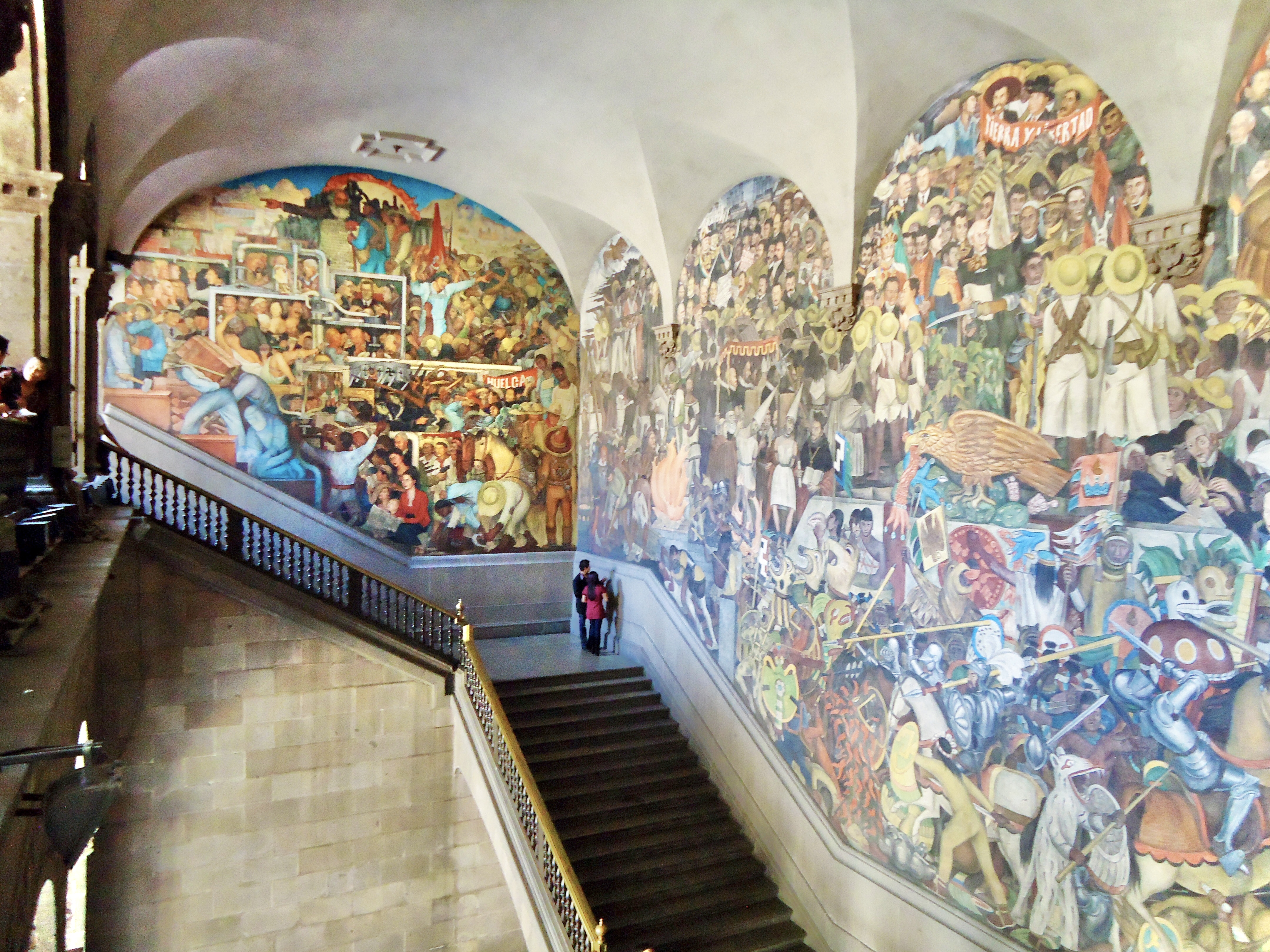 View of Diego Rivera's murals inside the Palacio Nacional, Mexico City, depicting Mexican history and revolution.