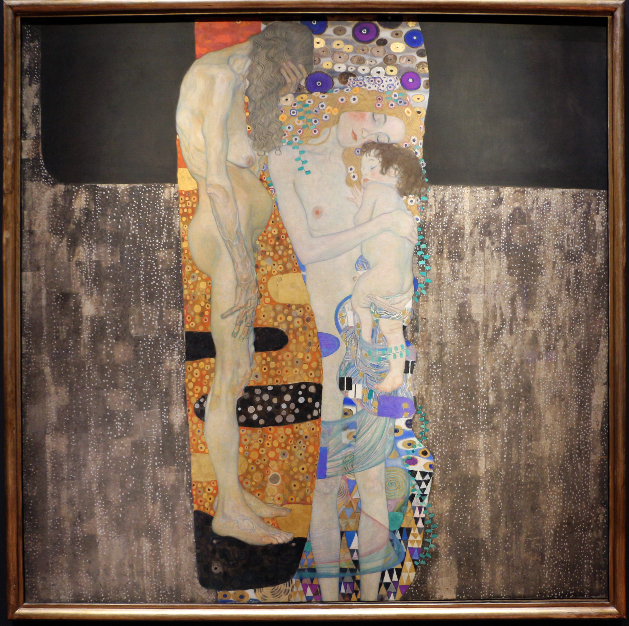 Gustav Klimt's 'The Three Ages of Woman' painting, depicting a young mother cradling her child, with an older woman in the background.