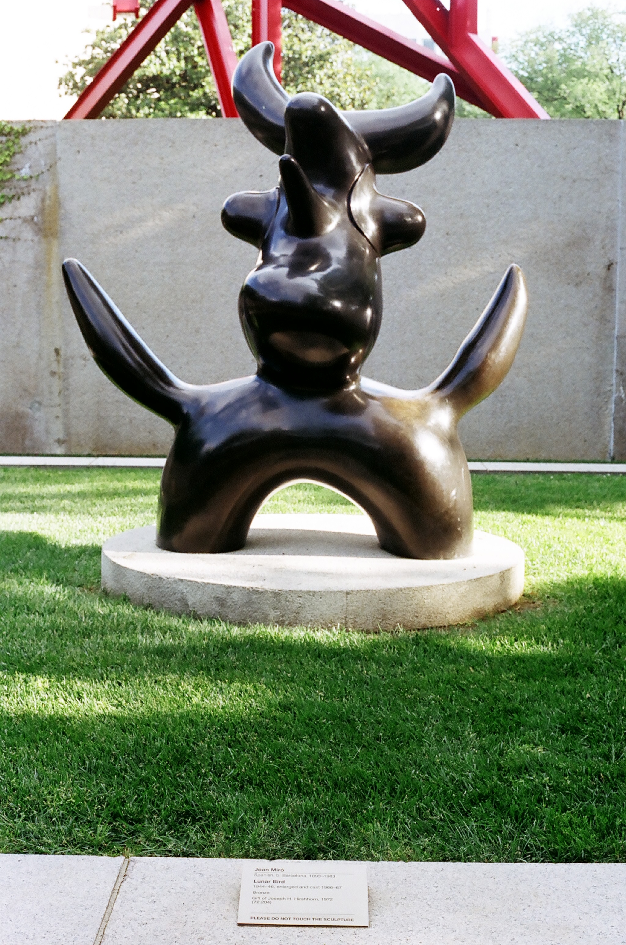 Joan Miró's bronze sculpture 'Lunar Bird' on a concrete pedestal in the Hirshhorn Sculpture Garden.