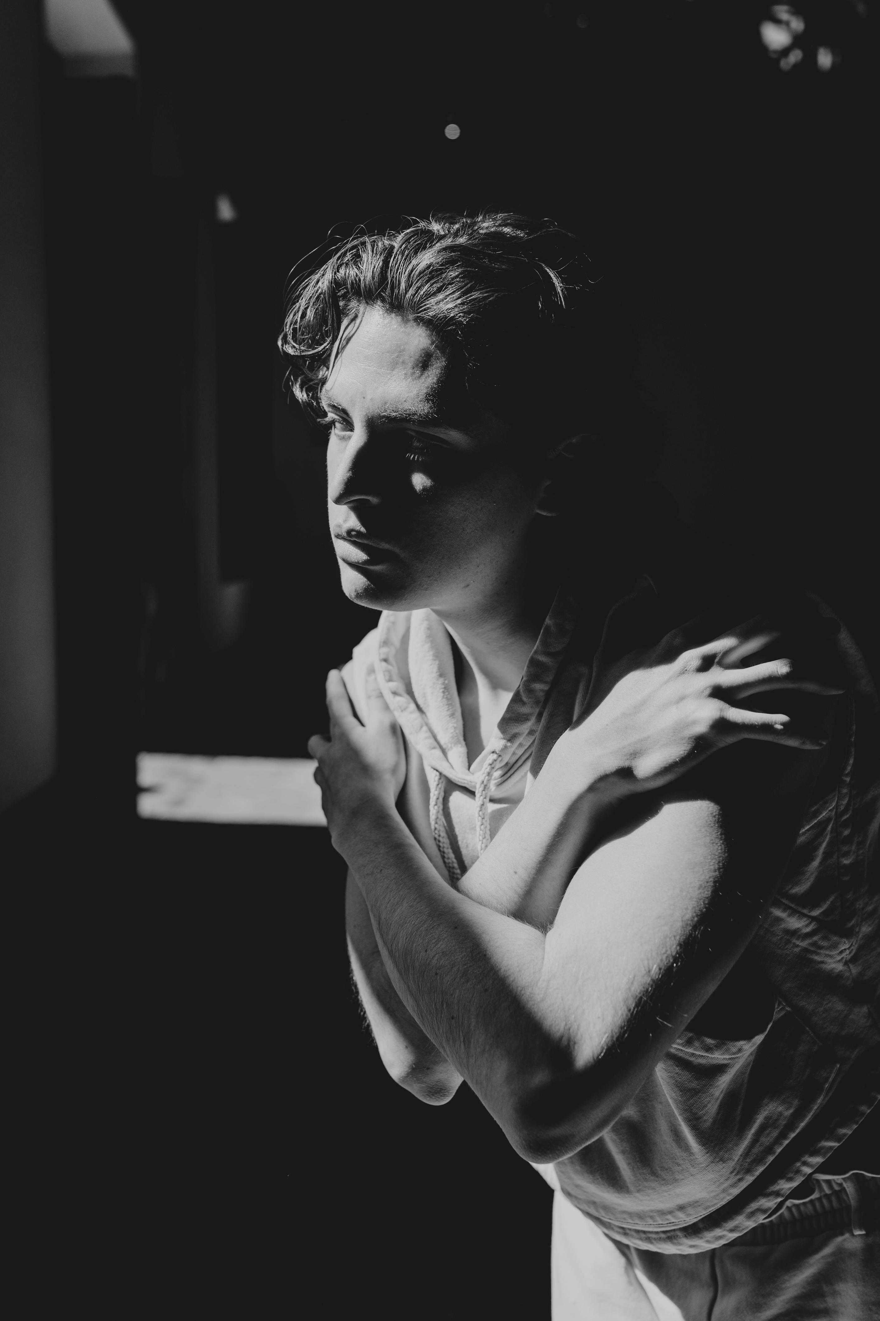 A dramatic black-and-white portrait of a dancer capturing chiaroscuro lighting effects and shadow dynamics. Free stock photo for editing and download on Unsplash.