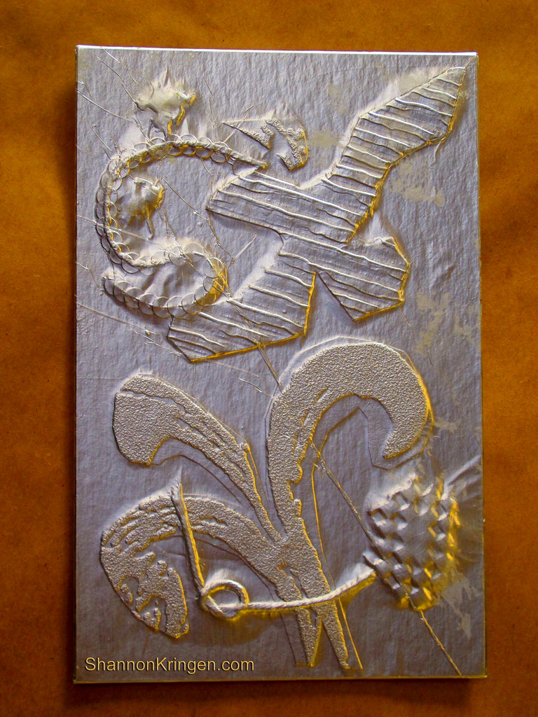 Collograph plate from a monoprint class, featuring raised textures and gold accents.