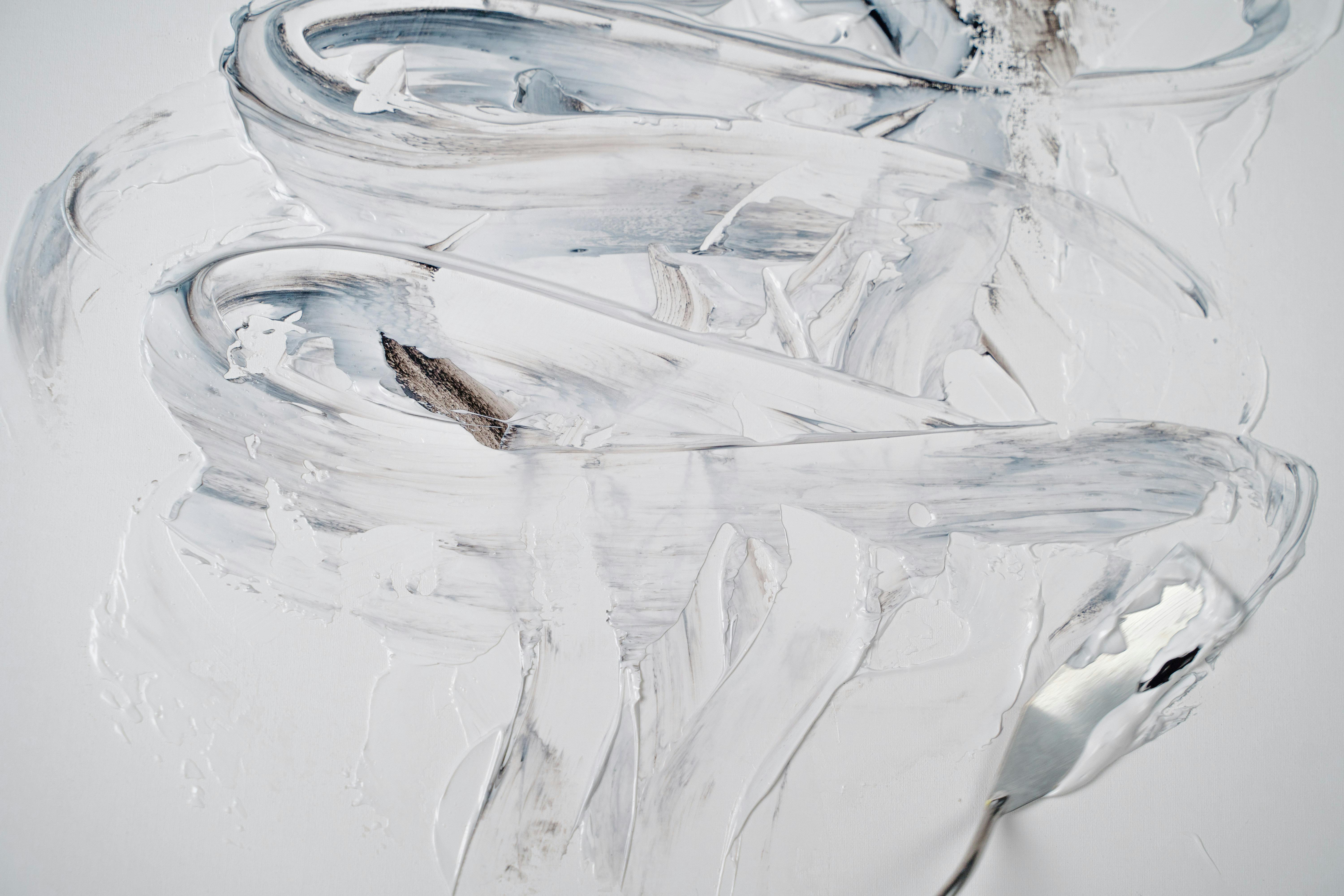 Abstract texture created with a palette knife and white and grey paint, showcasing thick impasto strokes and subtle color variations.