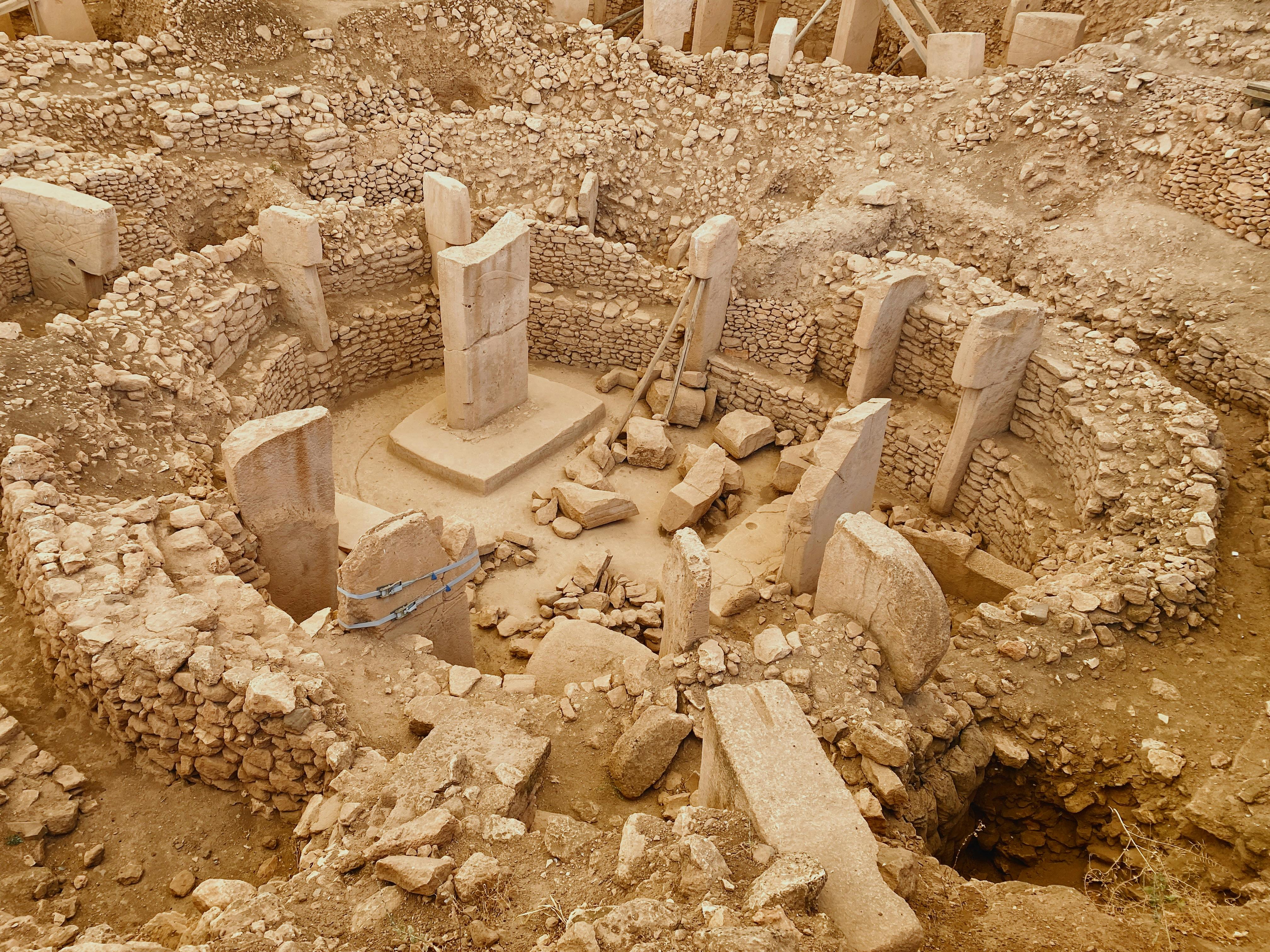 View of Göbekli Tepe, an ancient archaeological site with T-shaped megalithic pillars and stone walls.
