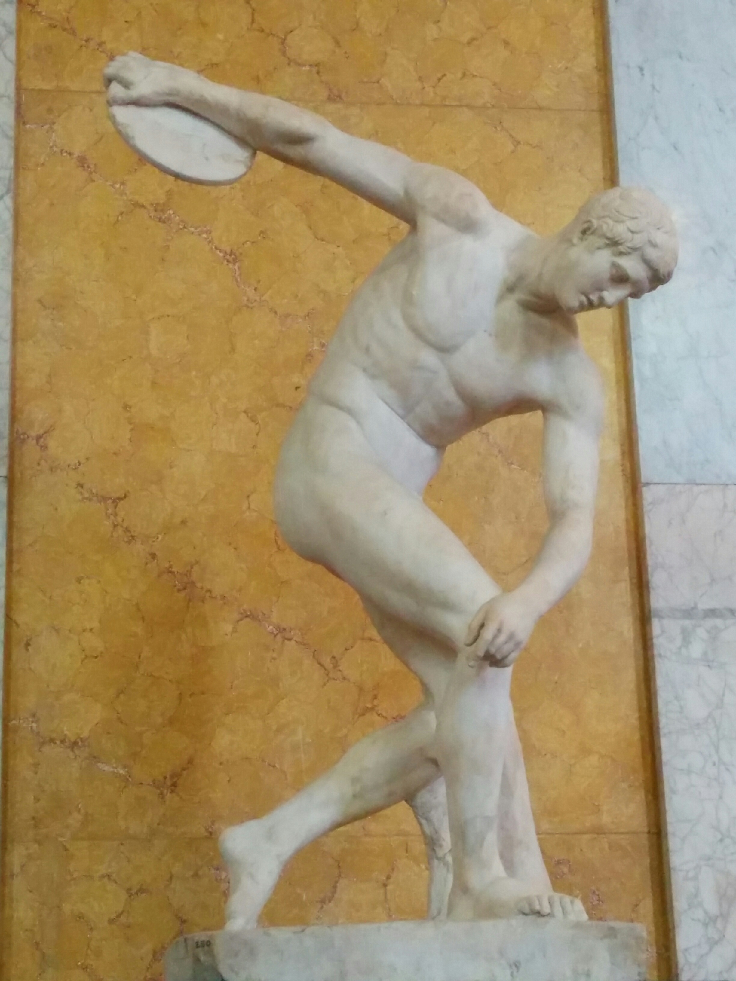 Side view of the Discobolus statue, an ancient Greek sculpture depicting an athlete in the motion of throwing a discus.