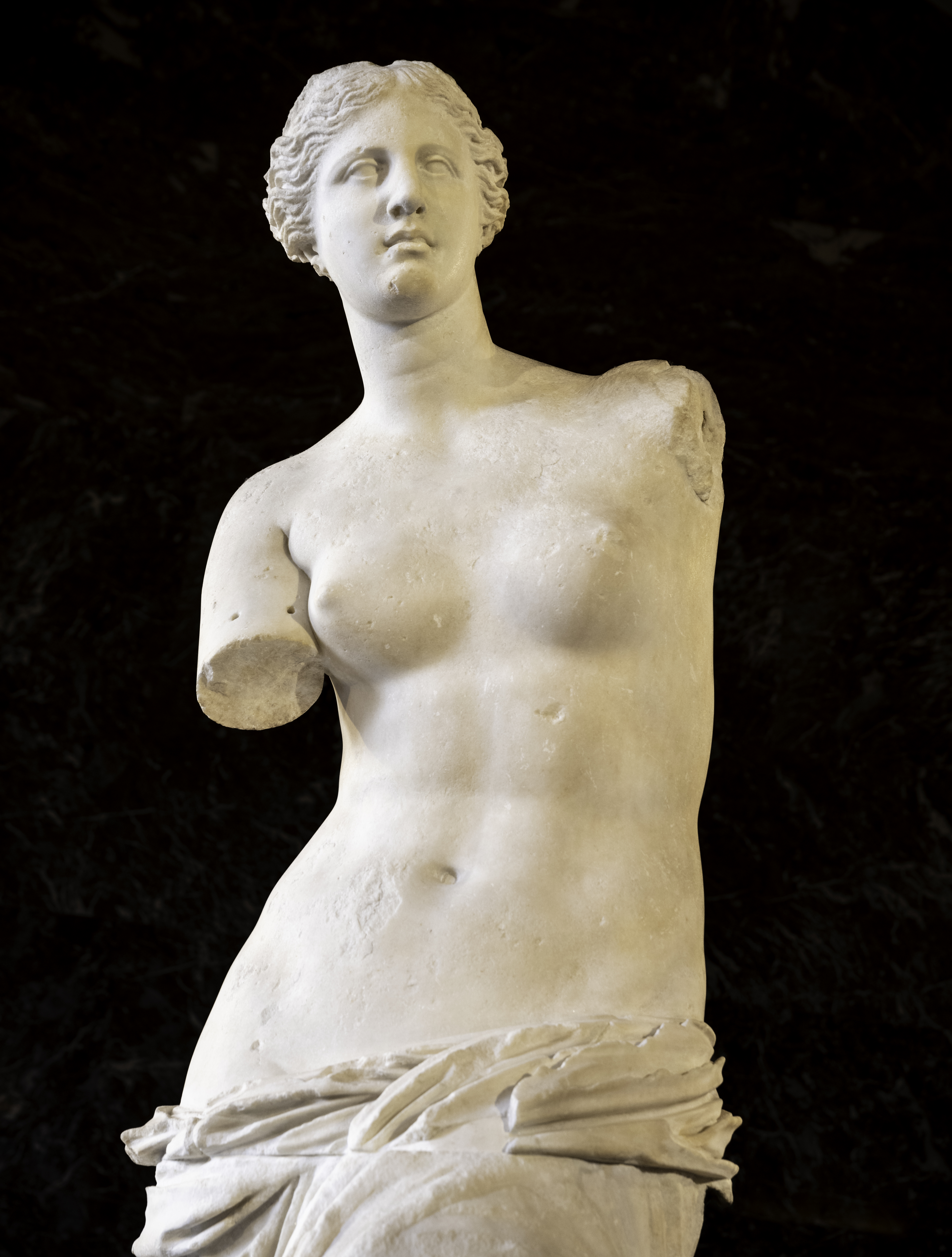 Front view of the Venus de Milo statue, a famous ancient Greek marble sculpture displayed at the Louvre Museum.