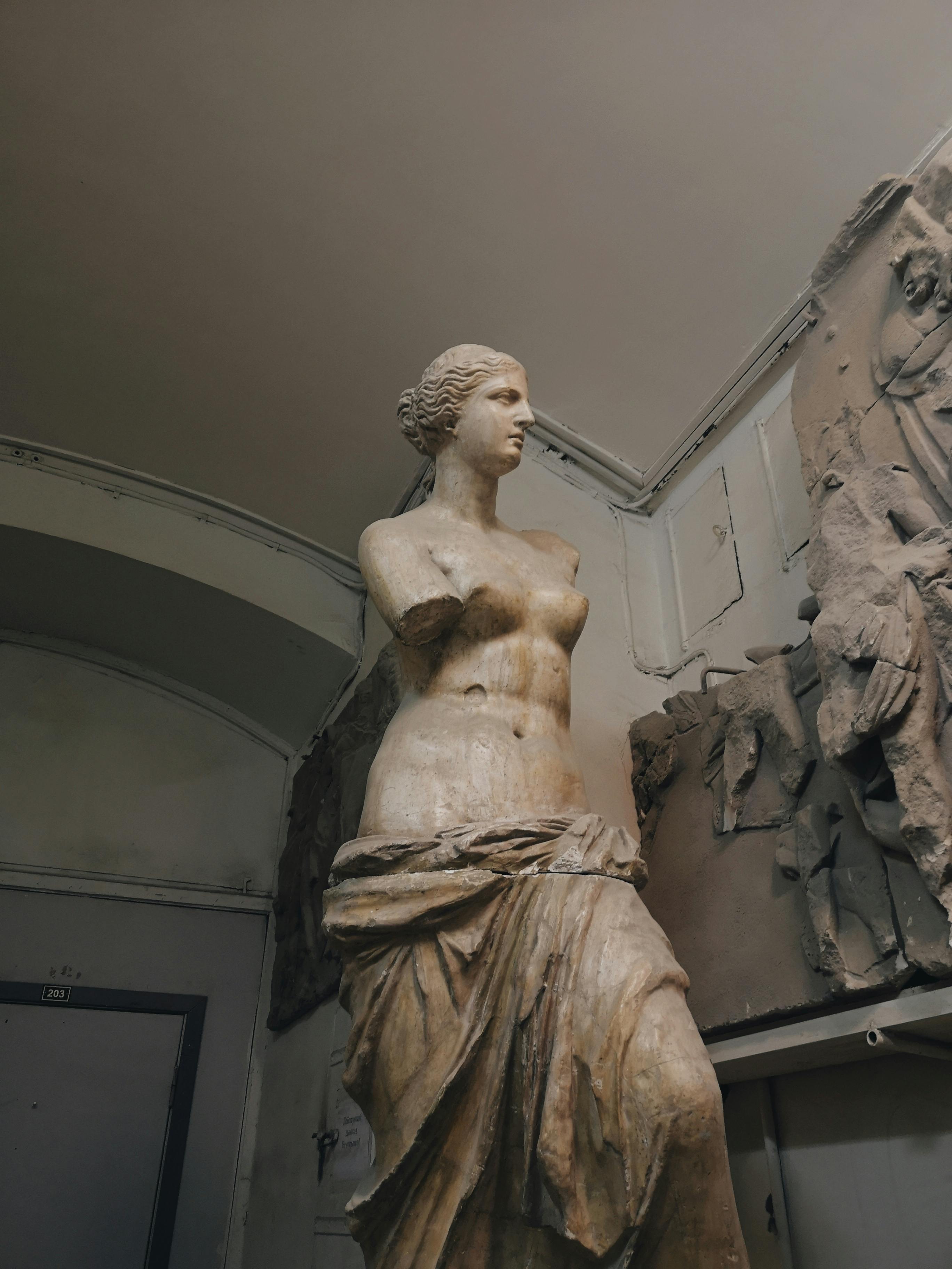 The Venus de Milo statue, a famous ancient Greek sculpture of Aphrodite, displayed in a museum setting.