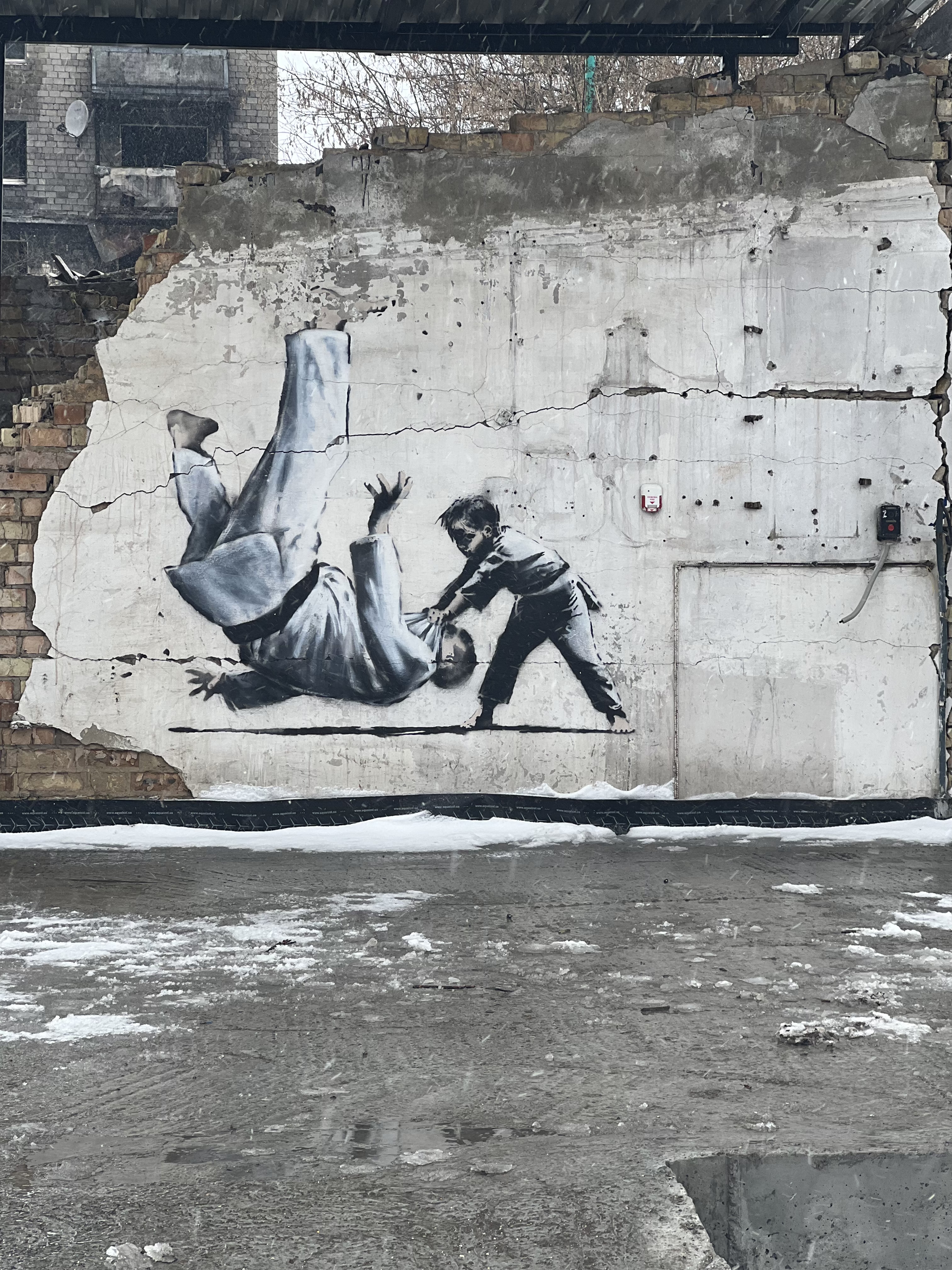 Banksy mural in Borodyanka, Ukraine, depicting a child performing a judo throw on a man.
