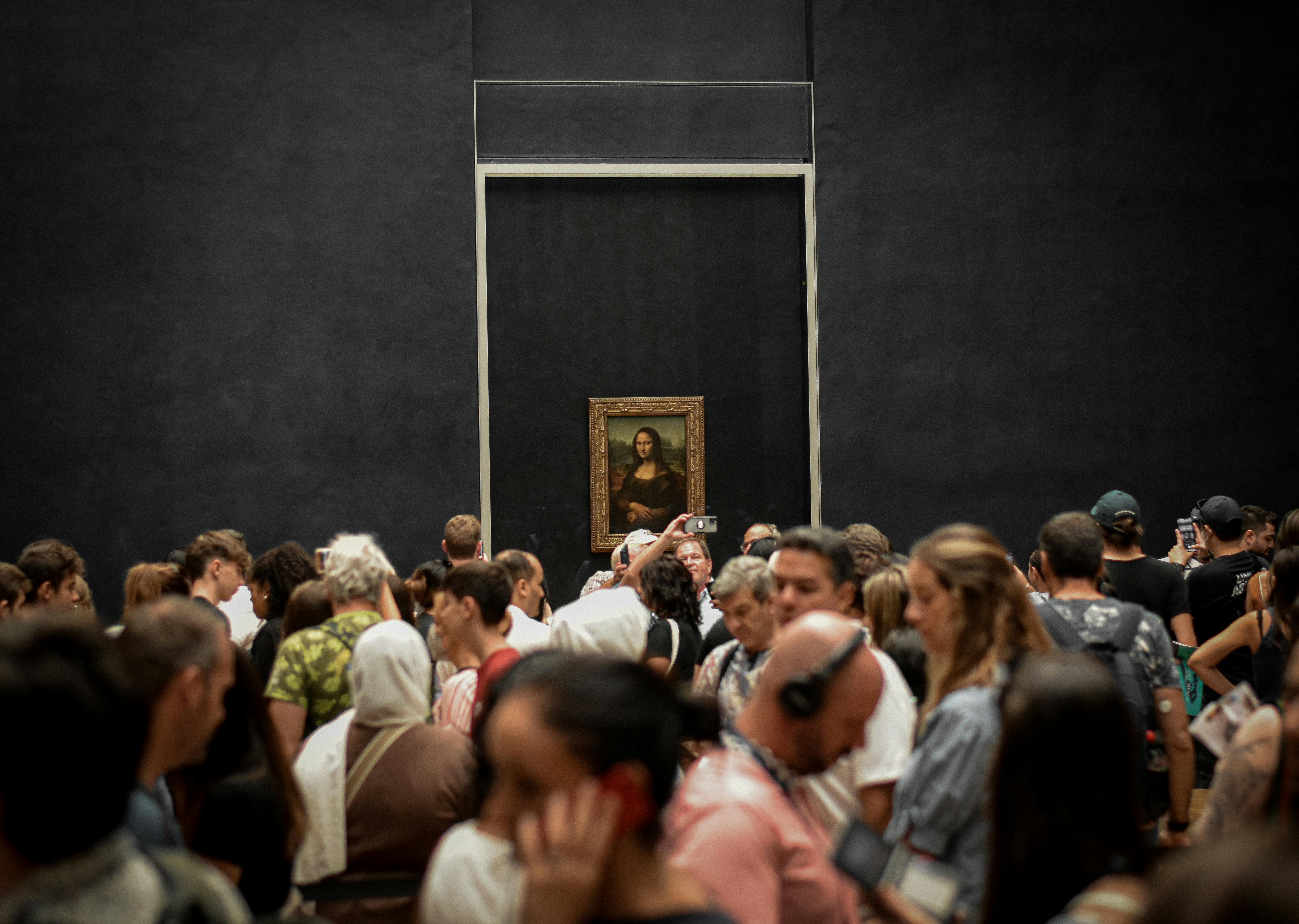 Crowd of visitors gathered to see the Mona Lisa painting at the Louvre Museum, Paris.