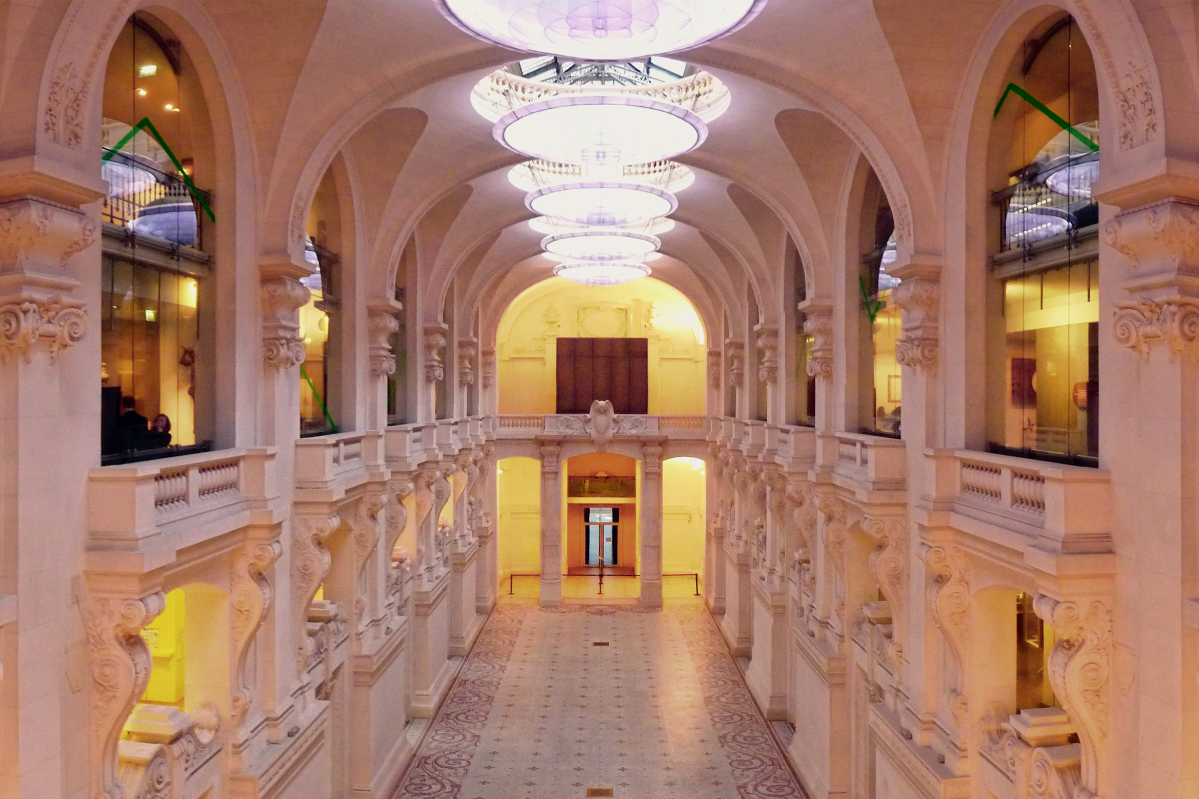 Interior view of the Musée des Arts décoratifs in Paris, showcasing its grand architecture with arched ceilings, ornate columns, and decorative floor.