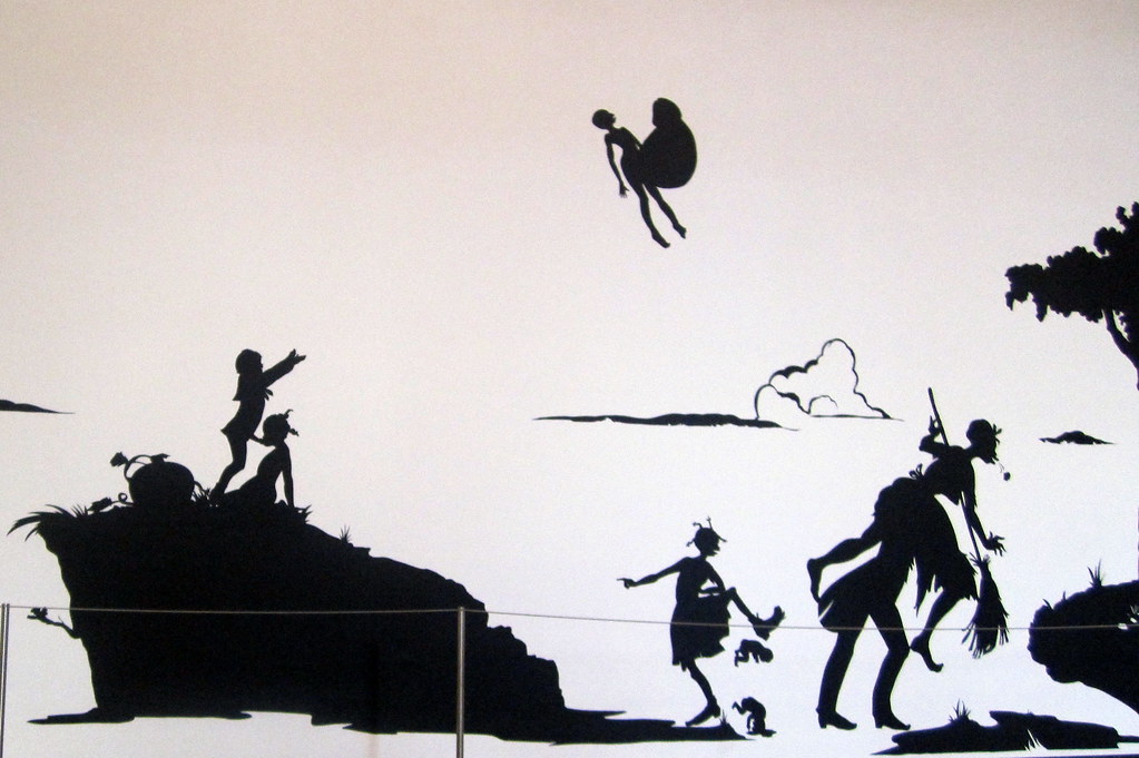 Black silhouette artwork from MoMA's 'Gone: An Historical Romance of a Civil War' exhibition, showing figures flying, on hills, and interacting in a stylized landscape.