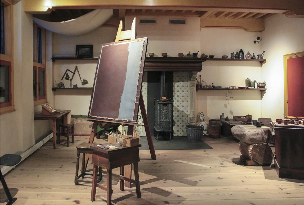Rembrandt's recreated 17th-century artist studio at the Rembrandt House Museum, featuring an easel, fireplace, and historical art tools.