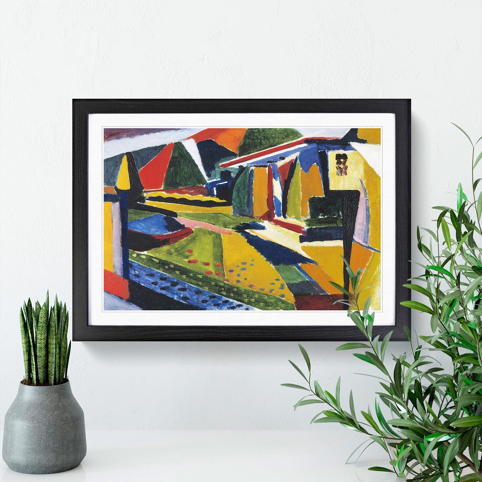 Framed abstract landscape painting by Henry Lyman Sayen with geometric shapes and vibrant colors, displayed on a white wall with two potted plants.