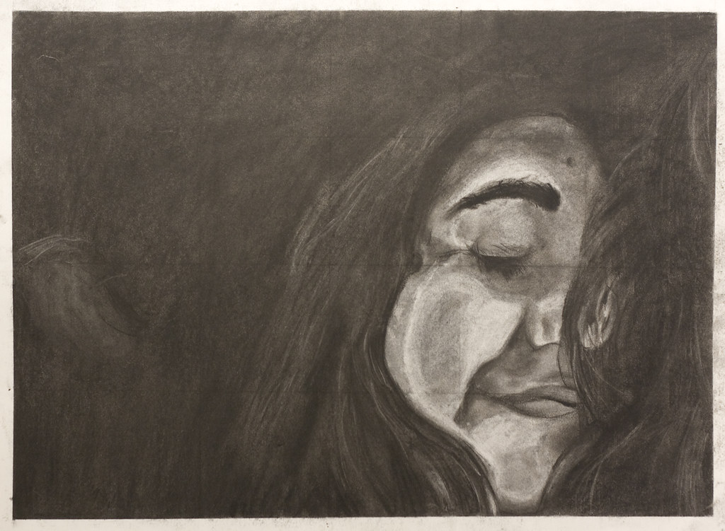 Charcoal self-portrait drawing, close-up of a face with eyes closed, rendered with dramatic shading and texture.